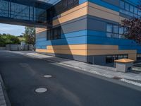 the street outside of a large modern building with colorful facades and windows that are made from steel