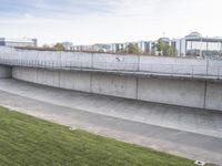 a wall of concrete near the side of a road with a sign on it next to an empty lot