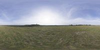 a field that is very close to the ground with clouds in the background and some grass