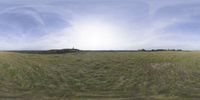 a field that is very close to the ground with clouds in the background and some grass