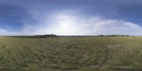 a field that is very close to the ground with clouds in the background and some grass