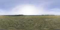 a field that is very close to the ground with clouds in the background and some grass