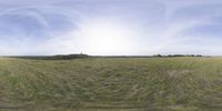 a field that is very close to the ground with clouds in the background and some grass