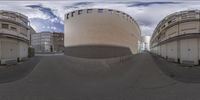 a fish eye image of several buildings on a street corner, each with a curved circular shaped design