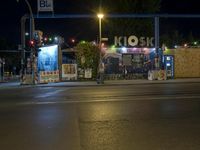 a street at night with no traffic on it's side and signs in front