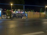 a street at night with no traffic on it's side and signs in front