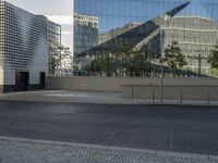 a black fire hydrant on the corner of a street next to a tall glass building