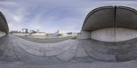 a guy with a skateboard is standing near an empty ramp with its mouth open