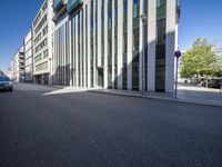 a building with glass walls along a city street side walk from the corner to the sidewalk