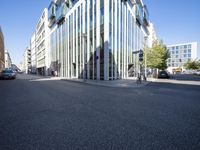 a building with glass walls along a city street side walk from the corner to the sidewalk