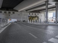 an empty street in a concrete airport, with parked planes in the background that are outside