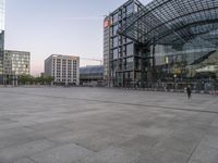 a building has an arched glass roof and is empty on a square in front of the building