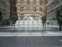 an open atrium is shown in this image, with a modern building behind it and plants growing between the floors