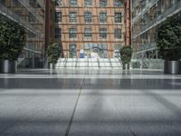 an open atrium is shown in this image, with a modern building behind it and plants growing between the floors