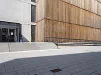 a building that is standing in the sun outside of it, with some stairs and steps