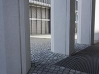 a young boy in sunglasses walks near the columns outside a building in a parking lot