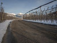 this rural country road has some skis hanging over it and there are snow on the ground