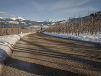 this rural country road has some skis hanging over it and there are snow on the ground