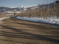 this rural country road has some skis hanging over it and there are snow on the ground