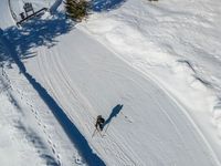 a skier makes his way up the slope towards a snow covered slope with ski tracks