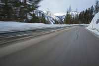 a blurred shot of trees and a mountain road in winter time, with blurry motion