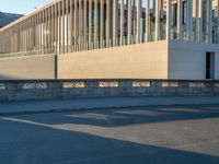 empty street lined with cement buildings next to a tall building with a staircase up to it