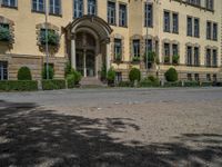 large yellow building with some plants and bushes in front of it for decoration or entertainment