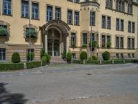 large yellow building with some plants and bushes in front of it for decoration or entertainment