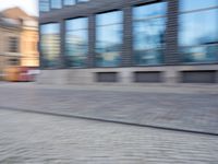 a man that is standing next to a skateboard in a street by some buildings