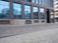a man that is standing next to a skateboard in a street by some buildings