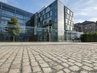 an office building sits beside an adjacent office in a city square in germany, where buildings appear to have glass walls