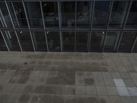 view of a walkway between two buildings with glass walls on the top and bottom floor