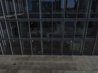 view of a walkway between two buildings with glass walls on the top and bottom floor