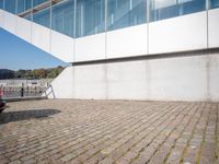 a bike leans against the edge of a brick walkway near a white building in a city