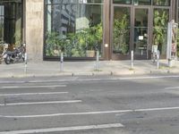 an empty city street with motor bikes parked in front of it and glass windows on one side