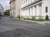 the small street is lined with beautiful architecture and cobblestone streets as well as buildings