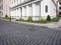 the small street is lined with beautiful architecture and cobblestone streets as well as buildings
