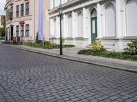 the small street is lined with beautiful architecture and cobblestone streets as well as buildings