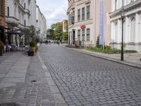 the small street is lined with beautiful architecture and cobblestone streets as well as buildings