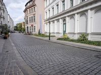 the small street is lined with beautiful architecture and cobblestone streets as well as buildings