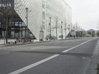 a street with many bikes parked by the side of it and buildings on both sides