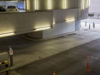 a parking garage with lights on and no signs attached to it by two traffic cones