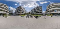 a 360 - lens image of several buildings with bikes parked near one another in front