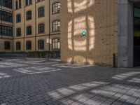 a brick courtyard has steps leading up to it, and a blue umbrella is on the ground