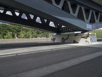 a man with a skateboard is walking under a bridge with graffiti on it's sides