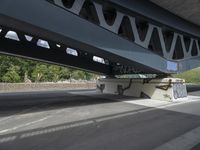 a man with a skateboard is walking under a bridge with graffiti on it's sides