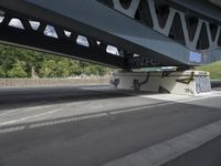 a man with a skateboard is walking under a bridge with graffiti on it's sides