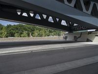 a man with a skateboard is walking under a bridge with graffiti on it's sides