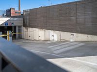 a man skateboarding in an enclosed parking garage area by a fenced off walkway