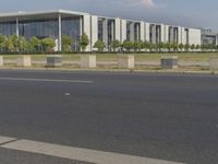 the buildings and green plants are near the road for vehicles to use as traffic signal